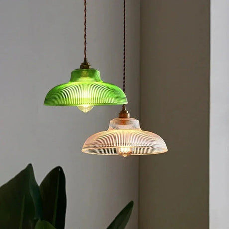 Green and amber prismatic shades hanging together above a leafy plant
