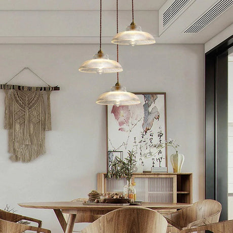 Three shades over a dining table in an open plan room with woven wall art