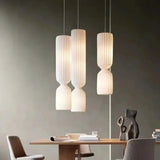 Pleated pendants hung above a wooden dining table
