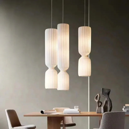 Pleated pendants hung above a wooden dining table