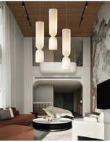 Three tall pleated pendants in a room with high walls