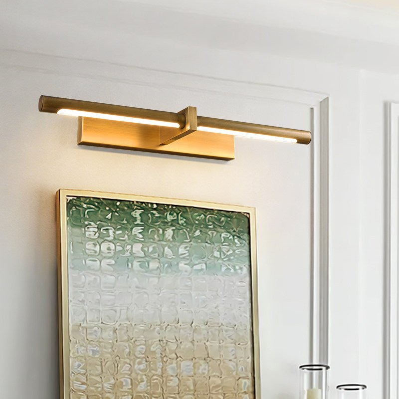 Brass twin bar lit above a large green framed canvas in a pale room