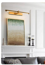 Brass twin bar lit above a green canvas over a mantel with candlesticks
