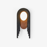 Stepped black arch wall lamp with a walnut oval and a white glass disc at the top