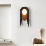 The arch lamp on a white wall beside a niche and the arm of a wool chair