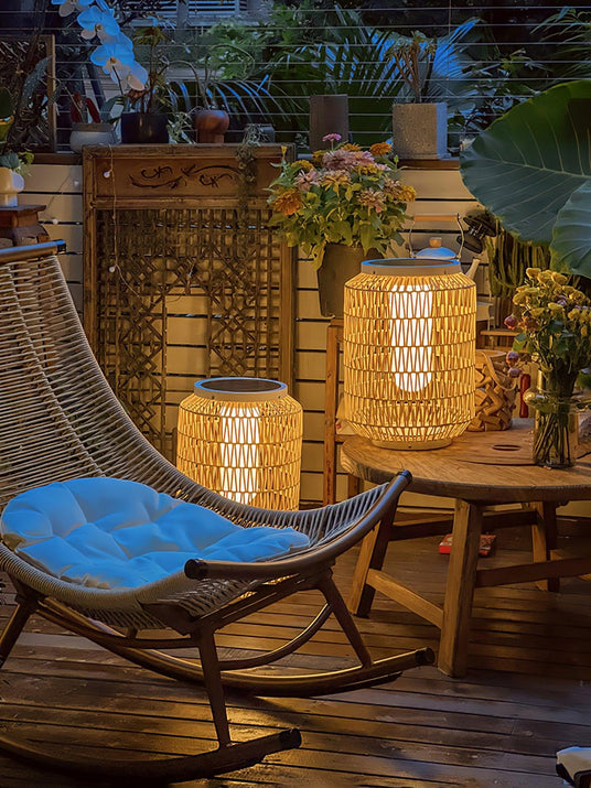 Lanterns lit on a balcony beside a hanging chair and potted planting