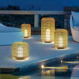 Lanterns lit along pale steps beside a lit pool with planting behind