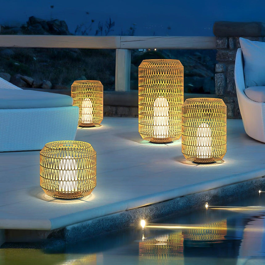 Lanterns lit along pale steps beside a lit pool with planting behind