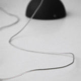 The ceiling plate with its cord coiled beside it on a plain gray field