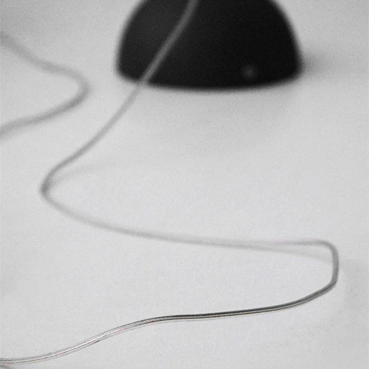 The ceiling plate with its cord coiled beside it on a plain gray field