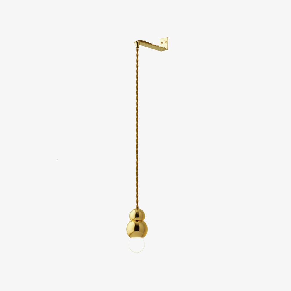 Gold wall light with an opal glass ball hanging from a twisted cord