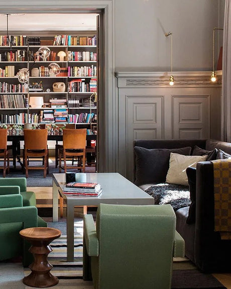 Ball lights along a lounge wall beside a library with armchairs