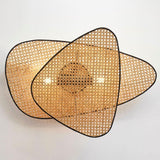 The large sconce of three overlapping cane screens lit, spreading wide