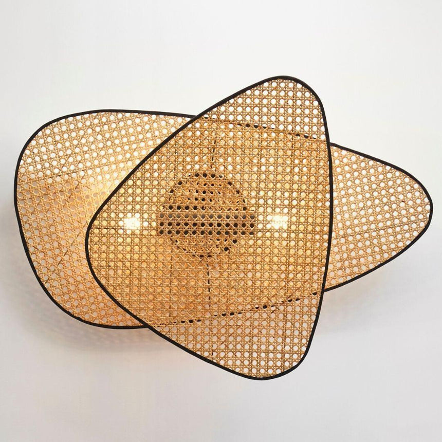 The large sconce of three overlapping cane screens lit, spreading wide