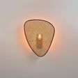 A single cane panel lit from behind, the bulb glowing through the weave