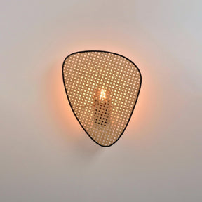 A single cane panel lit from behind, the bulb glowing through the weave