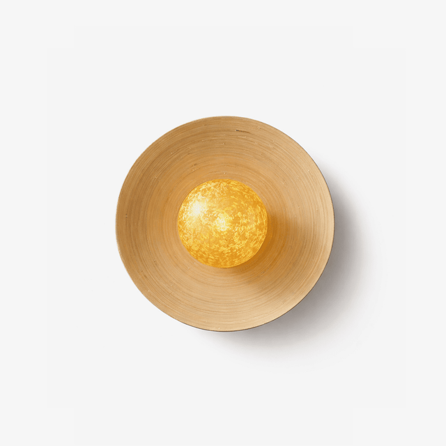 Bamboo wall sconce, a curved woven disc cradling a gold glass orb