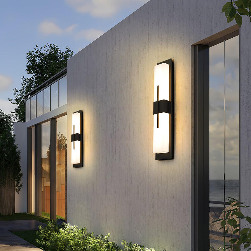 Bar lights spaced along the long white wall of a modern house beside tall glass