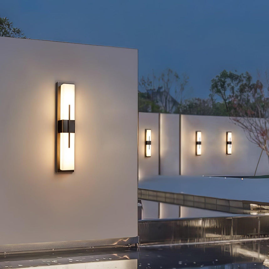 Bar lights on white garden walls above a pool at dusk