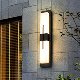The light lit on a slate tile wall beside a window with wood blinds