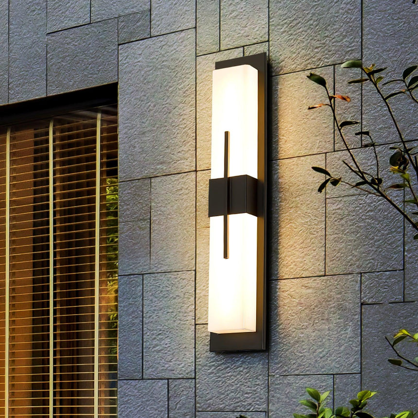 The light lit on a slate tile wall beside a window with wood blinds