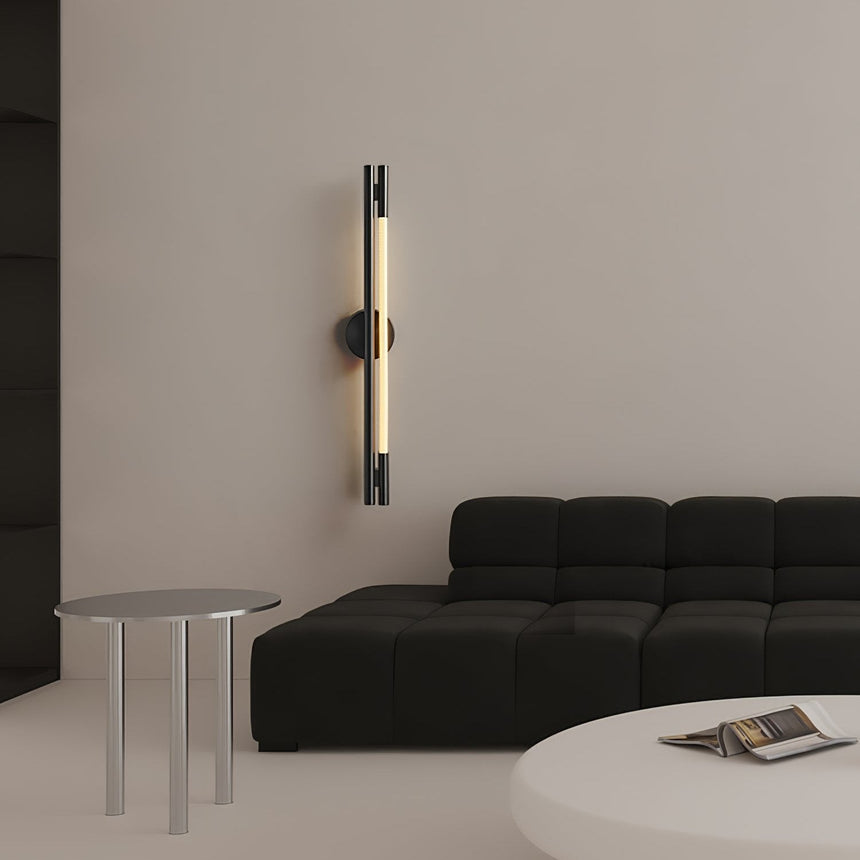 The lit bar on a beige wall above a black sofa and a round table