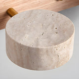 A single travertine disc seen alone, showing the porous surface of the stone