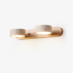 Bathroom vanity sconce with three travertine discs on a light wood bar