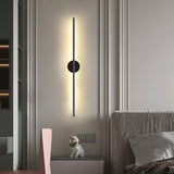 Lit beside an open doorway in a bedroom, a nightstand and bed just visible