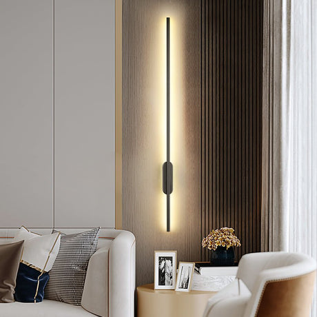 Lit on a timber wall beside an armchair, a side table and framed pictures