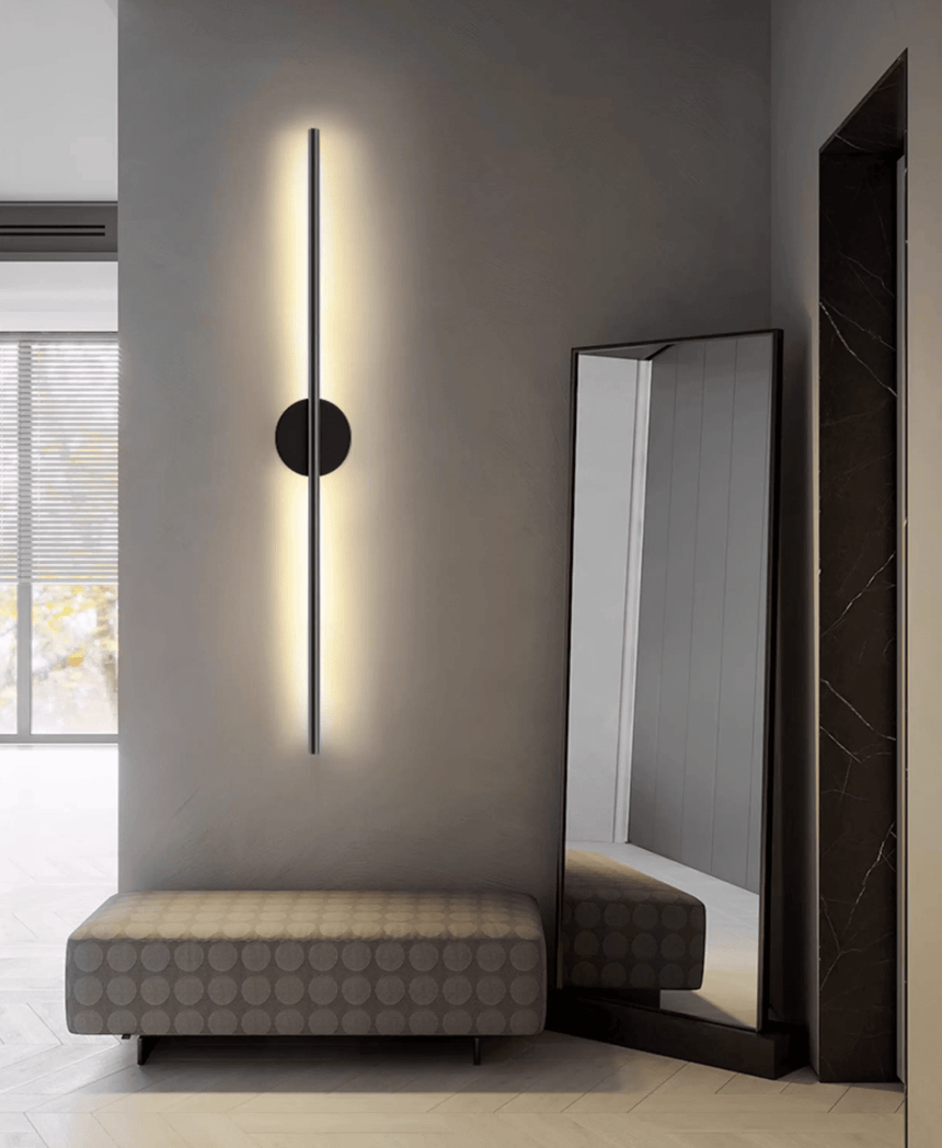Lit beside a tall leaning mirror above a low upholstered bench and window