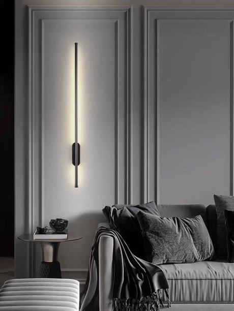 Lit on a paneled wall beside a chair with a throw and a small round table