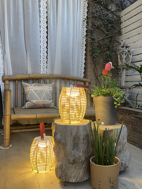 Two lit beside a timber bench with a pillow and potted planting