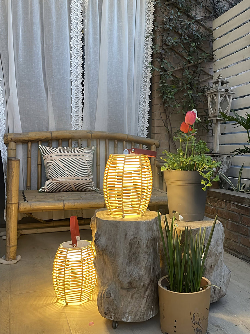 Two lit beside a timber bench with a pillow and potted planting