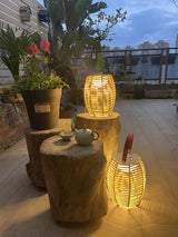 Two lit on timber stumps beside potted plants on a roof terrace