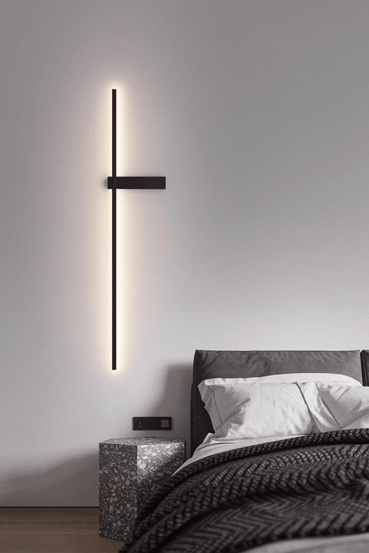 Lit beside a bed with a knitted throw, the crossbar mount at hand height