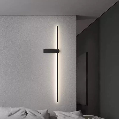 Lit on a bedroom wall beside a bed with pale bedding and a dark partition