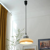 The saucer shade lit along a corridor with framed artwork on the wall