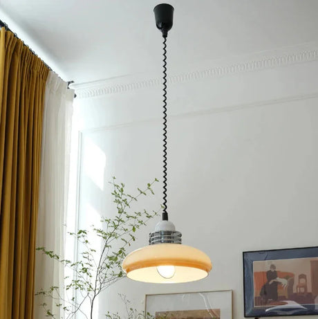 The saucer shade lit along a corridor with framed artwork on the wall