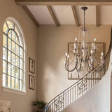 Lit in a stairwell beside an arched window and a run of framed pictures
