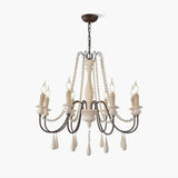 Wooden bead strands swagged across scrolling iron arms with candle lamps above