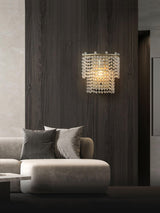 The beaded sconce on a dark wood wall above a white sofa