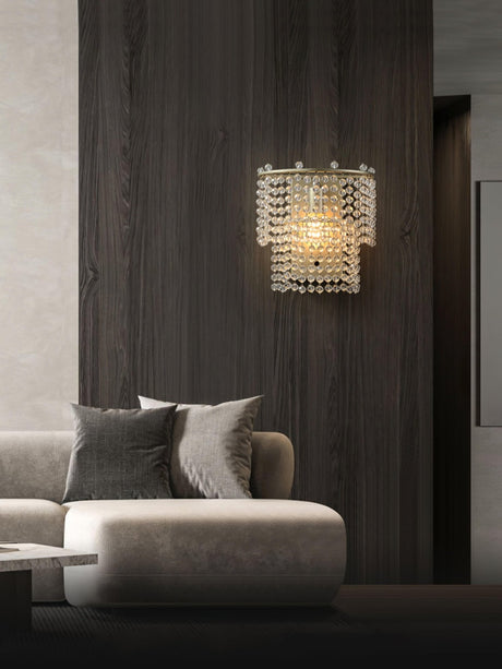 The beaded sconce on a dark wood wall above a white sofa