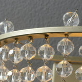Close view of the gold ring and the faceted crystal beads hanging from it