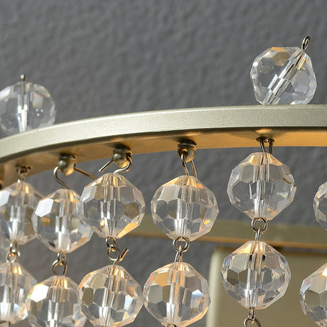 Close view of the gold ring and the faceted crystal beads hanging from it