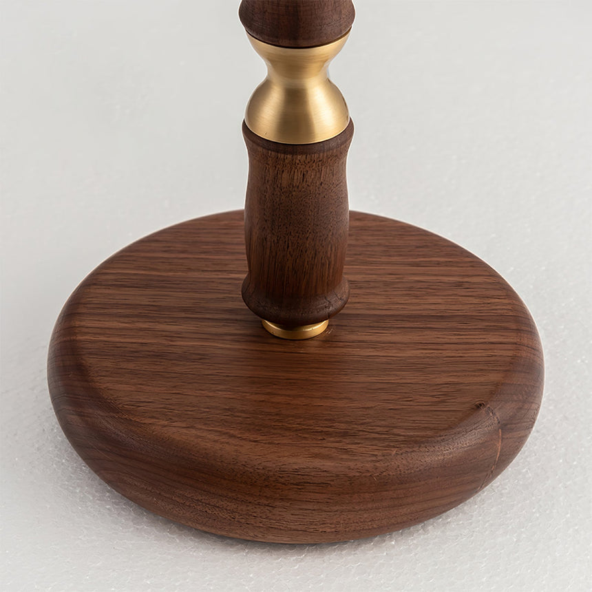 Close view of the brass collar where the stem meets the walnut disc base