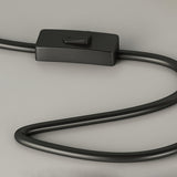 Close view of the inline push button switch on the black power cord