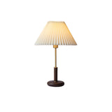 Pleated shade bedside lamp seen in full against a plain background
