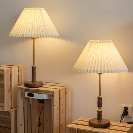 Two pleated shade lamps lit on wooden crates in a pale room