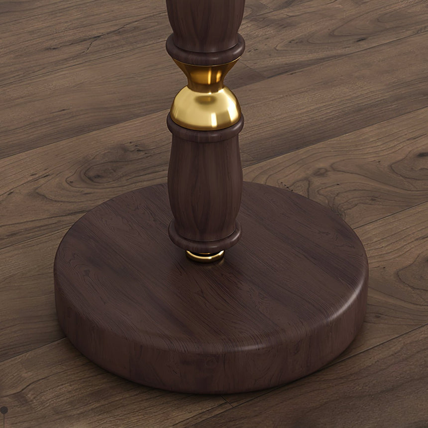 Close view of the round walnut disc base and the brass collar above it